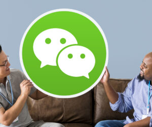 Men showing a WeChat icon